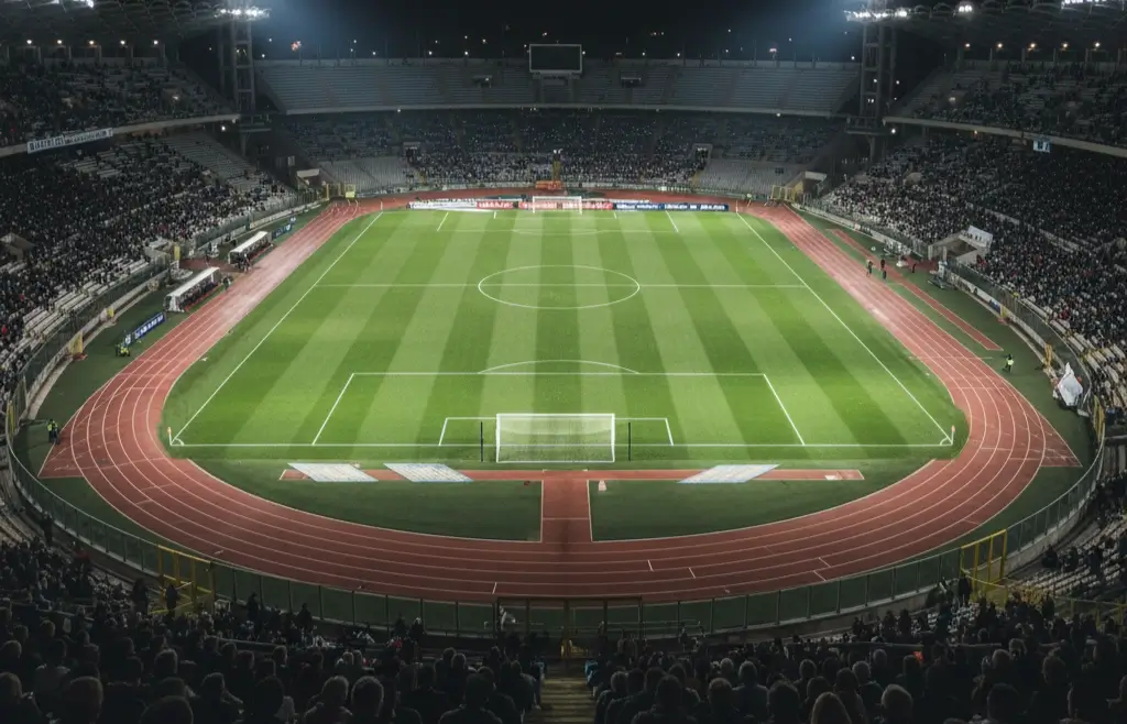 Stadio italiano di Serie A illuminato di sera con il campo da calcio in erba verde intenso